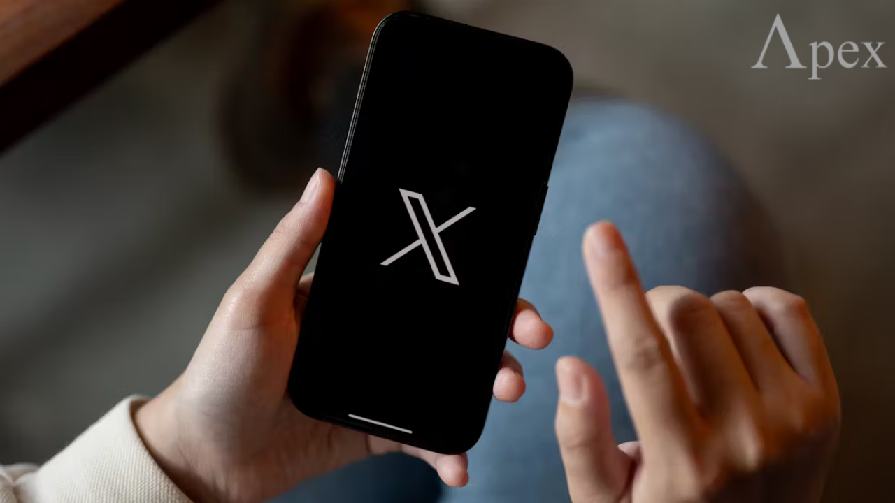 X (Twitter) app Person holding a smartphone showing the X logo.